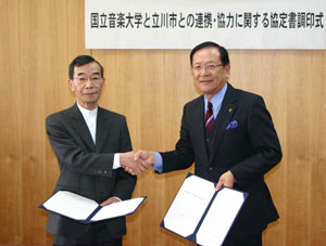握手を交わす立川市・清水市長（右）と本学・庄野学長